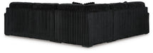 Black L-shaped sectional sofa with a distinctive vertical ribbed fabric texture, viewed from the back and side.