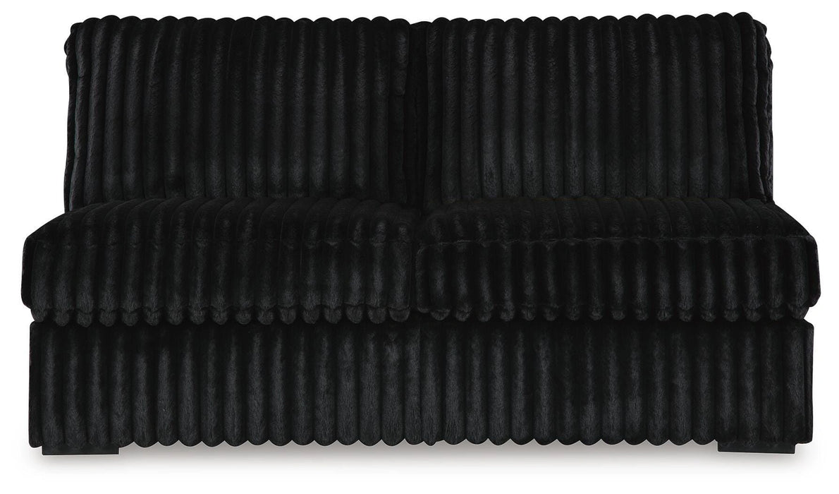 Plush black two-seater sofa with vertically ribbed upholstery. The modern loveseat features a scalloped edge detail between the seat and base.