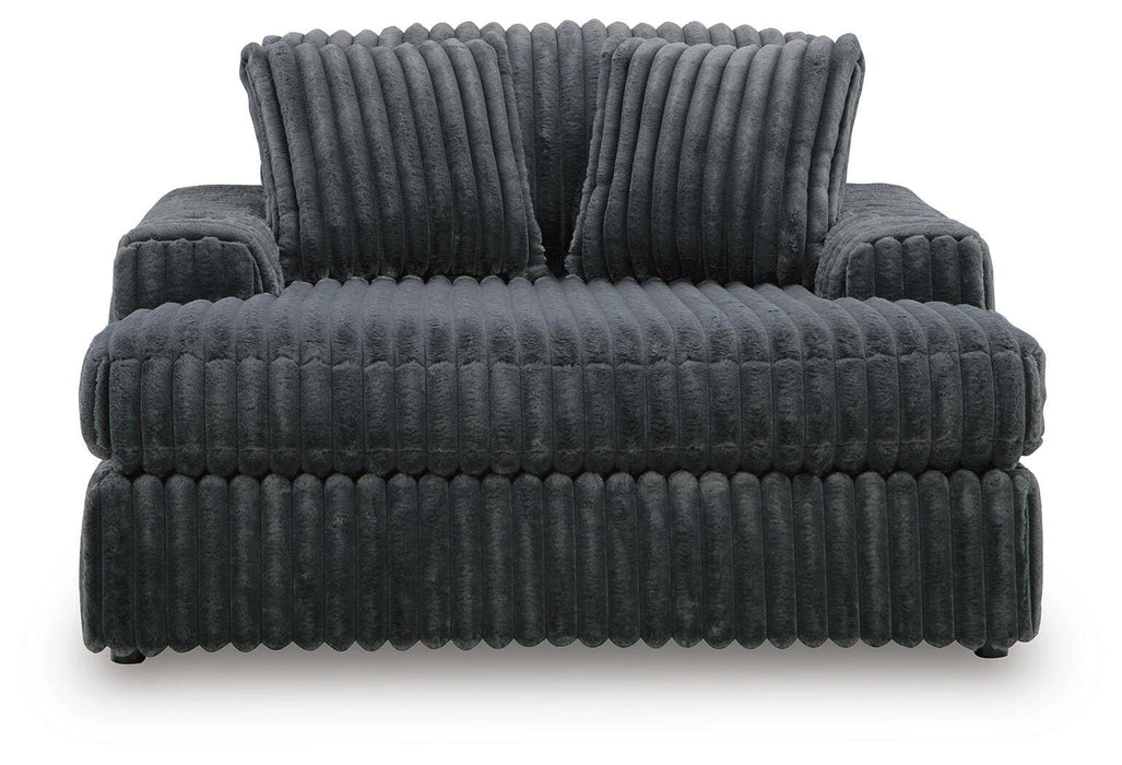 Dark grey plush ribbed oversized armchair with wide arms and two back cushions.