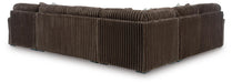 Back and side view of a large L-shaped sectional sofa upholstered in dark brown wide-wale corduroy fabric, with visible vertical ridges and small dark feet.