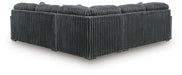 Dark gray L-shaped sectional sofa upholstered in a wide-ribbed corduroy-like fabric, viewed from the back and side, featuring plush back cushions.