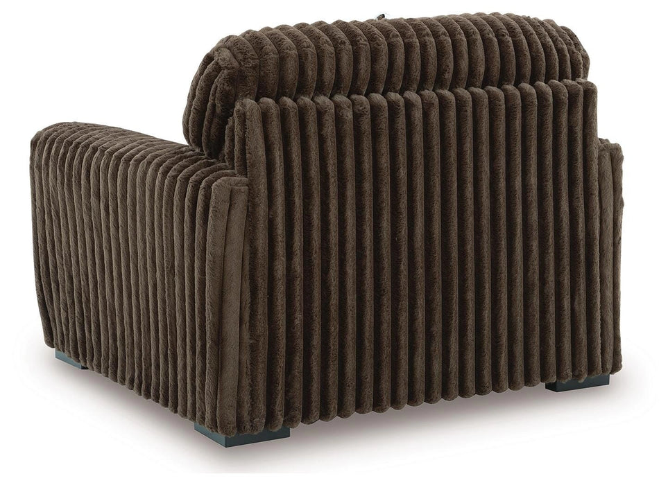 Brown ribbed fabric armchair, viewed from the back and side, featuring a plush texture and dark square feet.