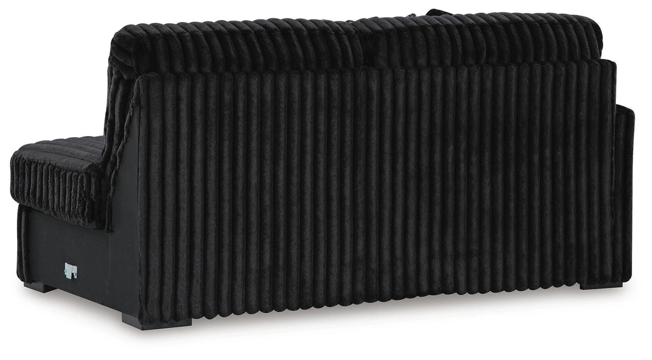 Back and side view of a black sofa upholstered in a plush, ribbed velvet-like fabric, showcasing the vertical texture and dark finish.