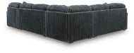 Dark gray corduroy sectional sofa, viewed from the back and side, showing the ribbed texture of the fabric on the back and base.