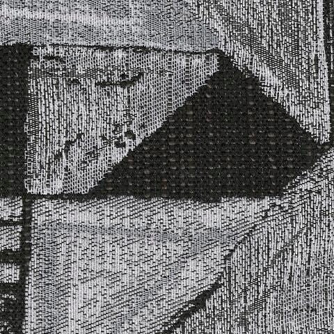 Close-up of a woven fabric swatch featuring an abstract geometric pattern in black and white. The texture shows visible threads.