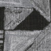 Close-up of a woven fabric swatch featuring an abstract geometric pattern in black and white. The texture shows visible threads.