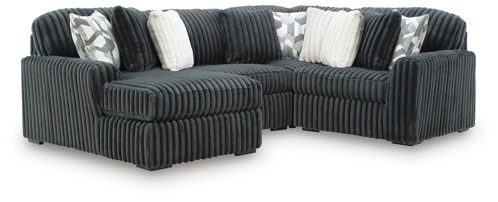 Dark gray L-shaped sectional sofa with plush, ribbed corduroy upholstery. Includes two white faux fur throw pillows and two gray and white geometric patterned pillows.