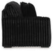 Black plush armchair with a deeply ribbed texture on the body and back cushions, featuring small dark feet, viewed from the side.